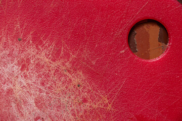 Red plastic kitchen cutting board with scratches and cuts as background