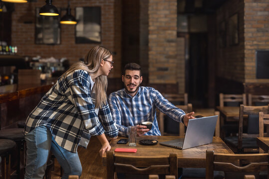 Bartenders, a waiter and a waitress, sit alone at the bar before the opening of a cafeteria or concept restaurant, before the start of business hours, talking and negotiating, expecting customers.