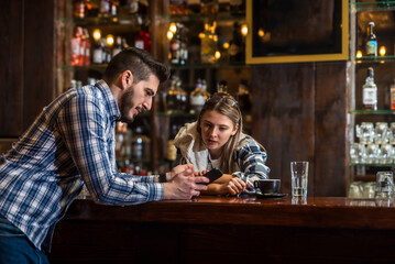 Bartenders, a waiter and a waitress, sit alone at the bar before the opening of a cafeteria or concept restaurant, before the start of business hours, talking and negotiating, expecting customers.