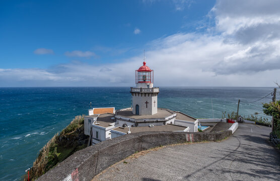 Farol do Arnel, der &auml;lteste Leuchtturm der Azoren, thront auf einem Felsvorsprung der Ponta do Arnel bei Nordeste, S&atilde;o Miguel. Wei&szlig; strahlend vor blauem Himmel und Meer, ein Symbol des Friedens.