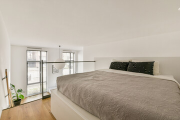 A beautifully designed minimalist bedroom showcasing a comfortable bed, elegant decor, and plenty of natural light streaming in from large windows.