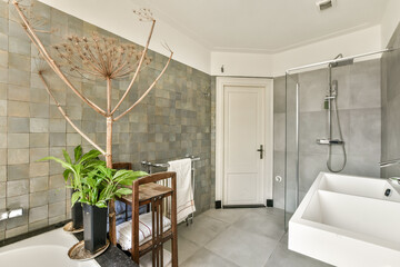 Featuring a minimalist aesthetic, this modern bathroom integrates natural elements like plants and...