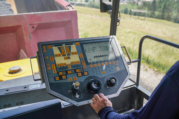 Close-up of asphalt paver control panel in use during road construction, highlighting complex machinery and operator’s role in surface precision