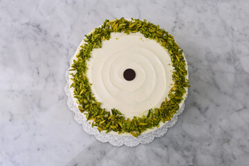 Elegant Pistachio Layer Cake featuring visible cake layers and a smooth white frosting decorated...