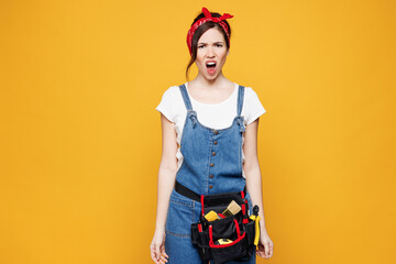 Young sad employee laborer handyman woman wear overalls belt look camera shout scream isolated on...