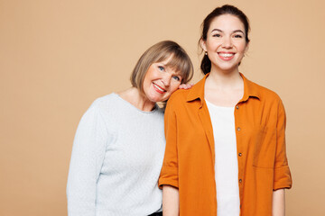Elder smiling happy parent mom 50s years old with young adult daughter two women together wear...