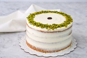 Elegant Pistachio Layer Cake featuring visible cake layers and a smooth white frosting decorated...