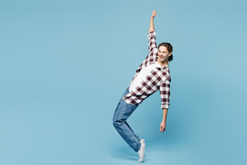 Obraz premium Full body young man he wear purple checkered shirt casual clothes standing on toes dancing lean back have fun spreading hands isolated on plain pastel light blue background studio. Lifestyle concept.