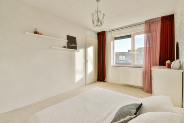 A stylish and airy bedroom featuring a white bedspread, elegant curtains, and minimalist decor, creating a serene and inviting atmosphere.
