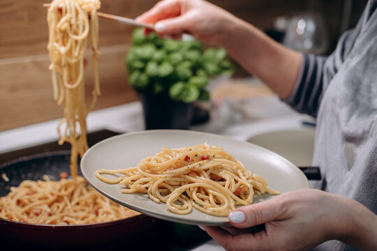 Step by step the process of cooking Italian pasta carbonara in spaghetti, add sauce with fried cubes of pancetta or bacon, eggs, cheese and garnish with basil