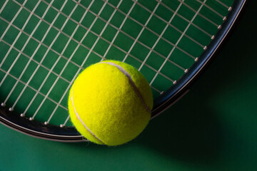 Tennis racket and balls on dark green background. Soft sidelight.Promotional background for tennis...
