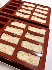 Homemade soap bars in silicone molds for crafting and business - concept of bath products