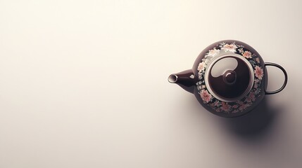 Brown teapot with floral design on white background.