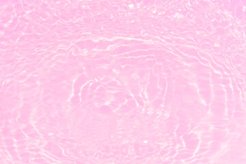 Fototapeta premium Pink water bubbles on the surface ripples. Defocus blurred transparent pink colored clear calm water surface texture with splash and bubbles. Water waves with shining pattern texture background