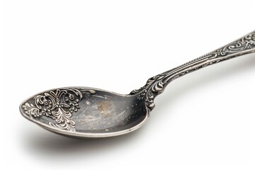 Intricate vintage silver spoon resting against a clean white background capturing timeless elegance