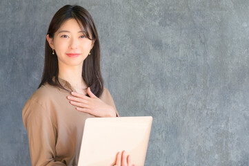 パソコンを持って案内をする日本人女性