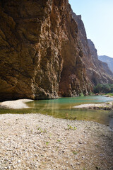 Beautiful landscape of most picturesque Wadi Shab. Rocks, lake and green tree. Sultanate Oman
