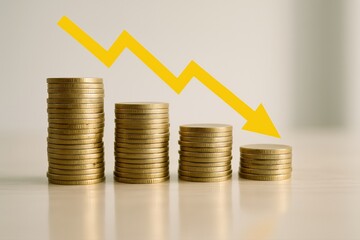 Decreasing Wealth Shown by Stacks of Coins and a Yellow Arrow Illustrating Economic Downturn and Financial Loss
