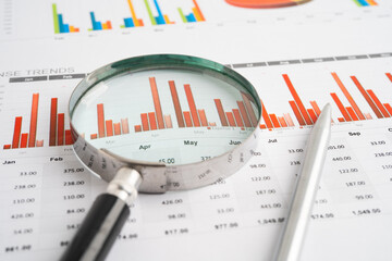 Magnifying glass on spreadsheet and graph paper. Financial data economy, Business.