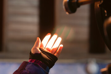 Hand illuminated by telescope light in dark observatory. The projection of the solar disk on the palm