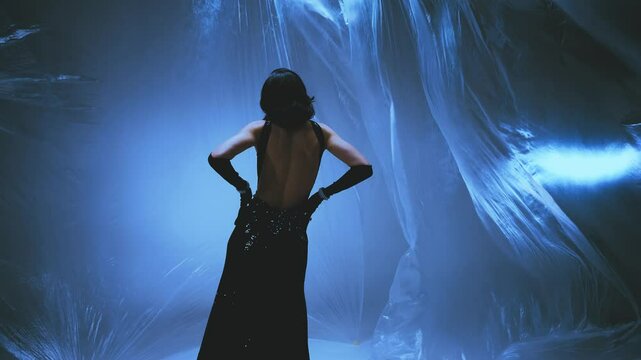 stylish fashion model girl dancing in dark studio, film fly wind slow motion. sexy beauty body gothic style woman queen festive long black dress elegant hair. ghost flashes light creative art shoot