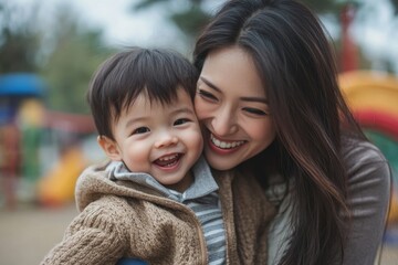Obraz premium Mother and son laughing and playing at the park