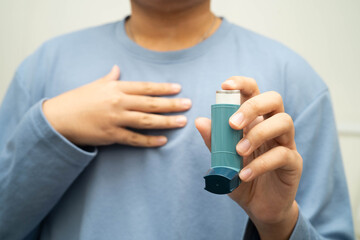Asthma and chronic obstructive pulmonary disease COPD, Asian young man using metered dose inhaler...