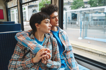 Young couple enjoying  quiet moment together while sitting on a bus in a vibrant city during the...