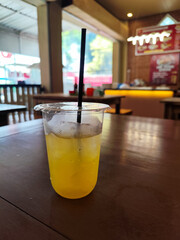 A glass of fresh cold orange ice on a table served in a traditional food stall.