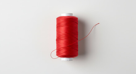 Red Sewing Thread Spool Standing Upright on White Background