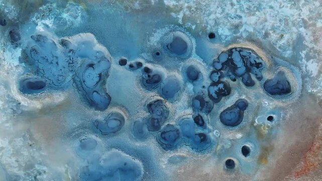Aerial shot of fumaroles and active boiling mud pits in Hverir, Iceland, illustrating geothermal energy release and sulfur deposits.