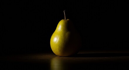 Yellow pear with dramatic lighting against a black background