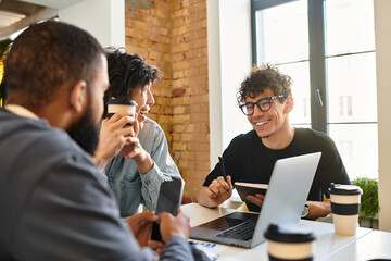 Engaging team discussion in a modern office space with coffee and technology