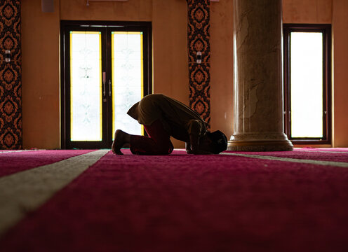 Silhouette of a person prostrating in the mosque.