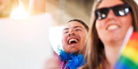 A joyful, diverse group at a pride event. Smiling man with a feather boa, woman with sunglasses....