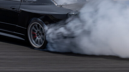 Car drifting on asphalt race track with lots of smoke from burning tires, Professional driver drift car on asphalt race track, Car motion blurred, Motorsport car drift.