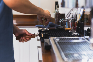 Barista hands leveling coffee in portafilter using powder distribution.