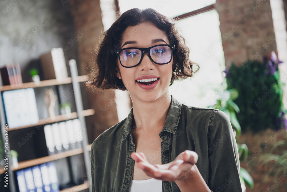 Poster casual female programmer in an office setting smiling with enthusiasm and confidence, representing a