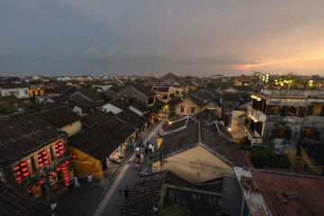 Roof tops and narrow street of cultural old town in Hoi An during colorful sunset in Vietnam
