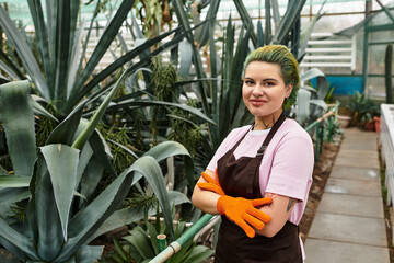 Young woman tending plants in vibrant green house with passion and dedication