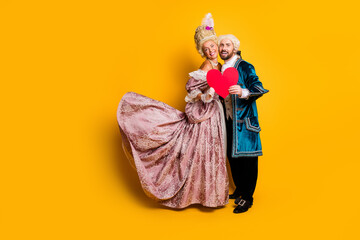 Elegant couple posing in vintage costumes showcasing historic fashion with royal charm and love.