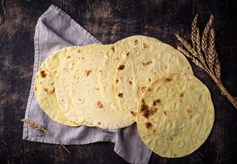 Lavash flat bread on green background