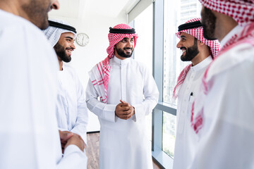 Arab businessmen wearing emirati and saudi kandura meeting in office for business deal - Corporate...