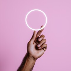 Dark Skinned Hand Holding Glowing White Circle Against A Pink Minimalist Background