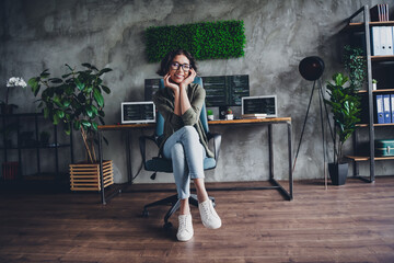 Casual professional woman working remotely in a modern workspace with confidence and enthusiasm