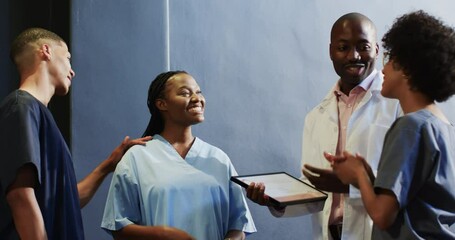 Diverse medical staff celebrating award ceremony in office at hospital with certificate and smiles