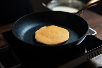 Cooking pancakes in pan on stove. Homemade breakfast.