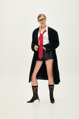 Stylish young woman showcases modern fashion in studio setting with creative flair