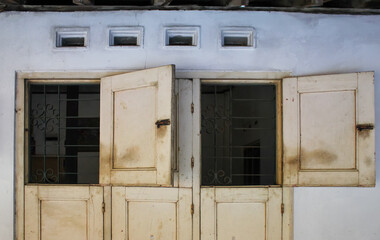 Fototapeta premium old yellow wooden window open on white wall