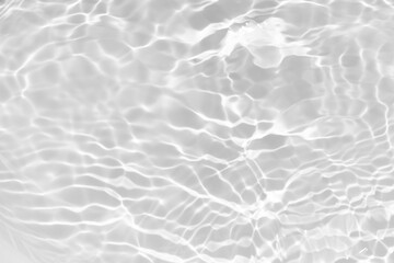 White water with ripples on the surface. Defocus blurred transparent white colored clear calm water surface texture with splashes and bubbles. Water waves with shining pattern texture background.